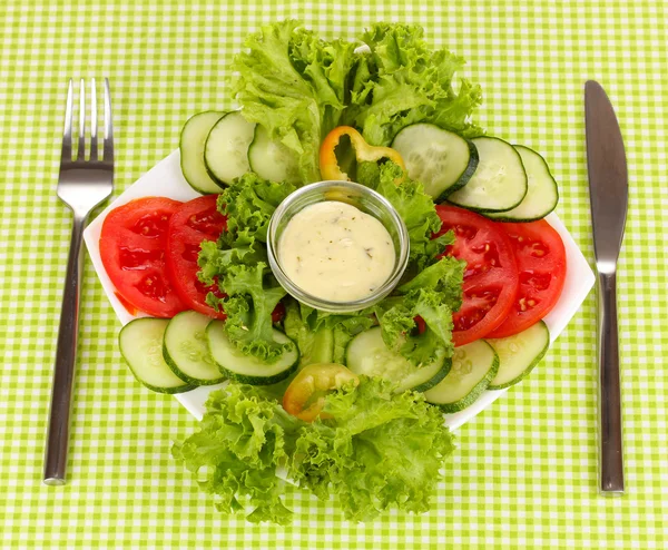 Verduras picadas y salsa en plato sobre mantel verde —  Fotos de Stock