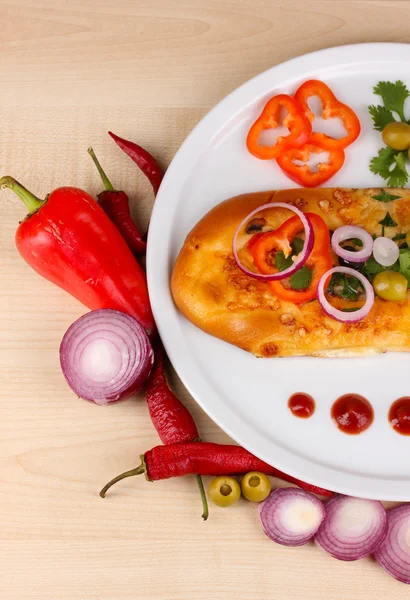 Delicious slice of pizza on plate with ingredients around close-up on wooden table — Stock Photo, Image