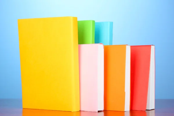 Stack of multicolor books on blue background — Stock Photo, Image