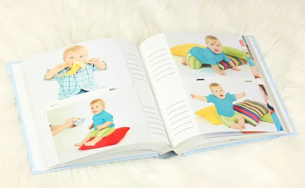 Open photo album with pictures on white carpet — Stock Photo, Image