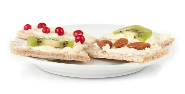 Sabrosos canapés con queso, kiwi y arándano, almendra, en plato de color, aislados en blanco — Foto de Stock