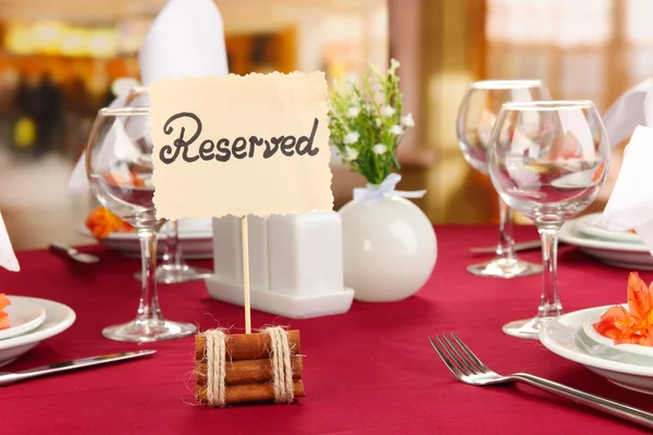 Sinal reservado na mesa do restaurante com pratos e copos vazios — Fotografia de Stock