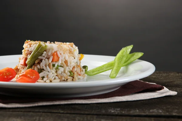 Delizioso risotto con verdure sul tavolo di legno, su fondo grigio — Foto Stock
