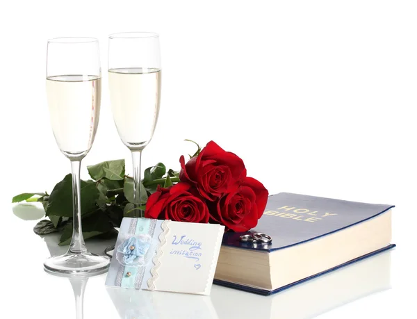 Trauringe auf Bibel mit Rosen und Champagnergläsern isoliert auf Weiß — Stockfoto