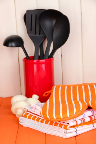 Kitchen settings: utensil, potholders, towels and else on wooden table — Stock Photo, Image