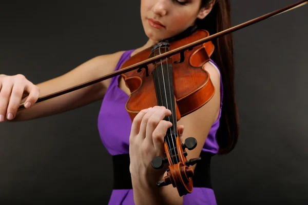 Hermosa joven con violín sobre fondo gris — Foto de Stock