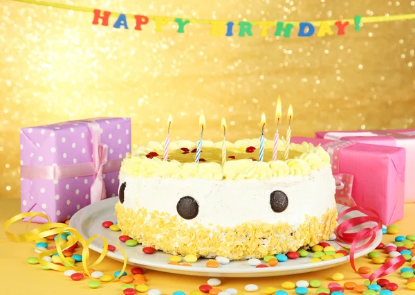 Happy birthday cake and gifts, on yellow background — Stock Photo, Image