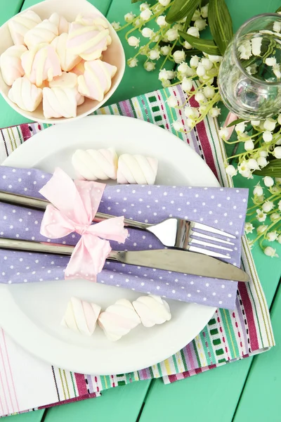 Tischdekoration in violetten und weißen Tönen auf farbigem Holzhintergrund — Stockfoto