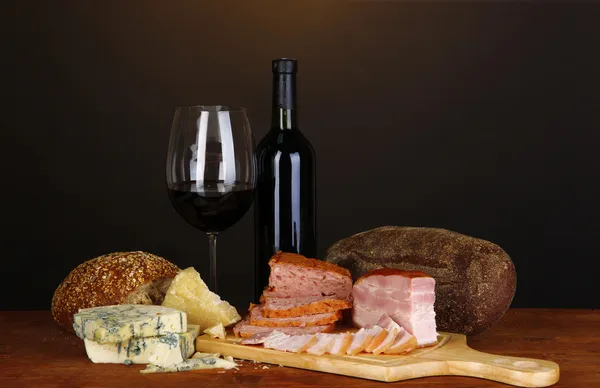 Exquisito bodegón de vino, queso y productos cárnicos — Foto de Stock