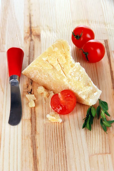 Piece of Parmesan cheese with knife on wooden table close-up — Stock Photo, Image