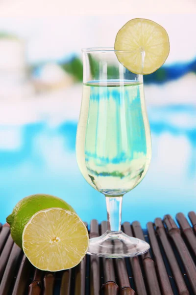 Green cocktail with lime on table on bright background — Stock Photo, Image