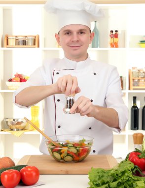 Şef mutfakta yemek yapıyor.