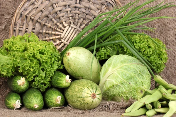 Verse groene groenten op rouwgewaad achtergrond — Stockfoto