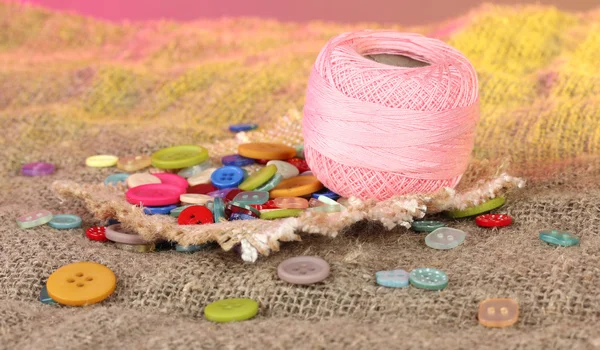 Beautiful buttons and a ball of yarn on a bright background — Stock Photo, Image