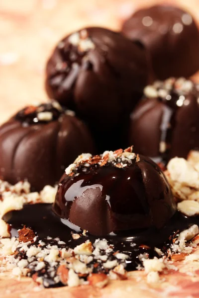 Caramelle al cioccolato con noci, su sfondo colore — Foto Stock