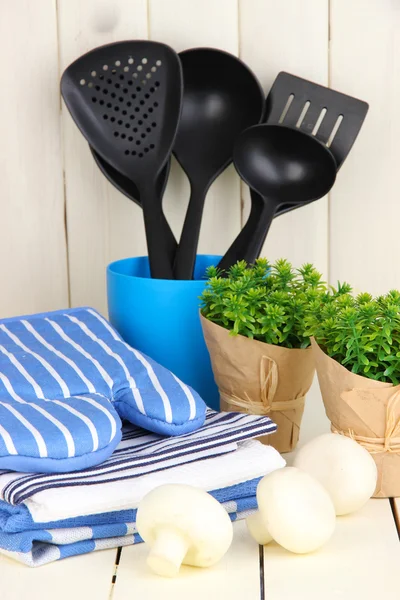 Ajustes de cocina: utensilios, agarraderas, toallas y más en la mesa de madera —  Fotos de Stock