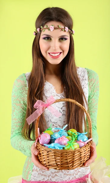 Felice cesto femminile con uova di Pasqua, su sfondo verde — Foto Stock