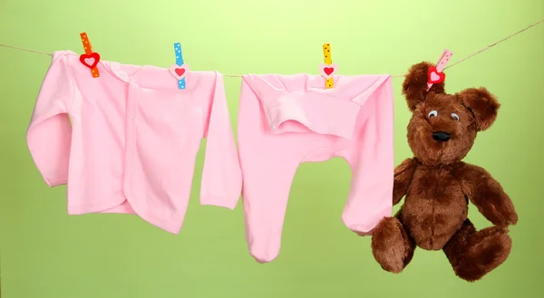 Dětské oblečení na prádelní šňůru na barvu pozadí — Stock fotografie