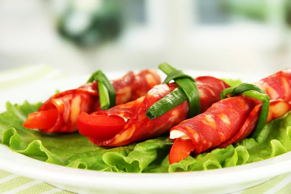 Rollos de salami sobre plato blanco sobre fondo brillante — Foto de Stock