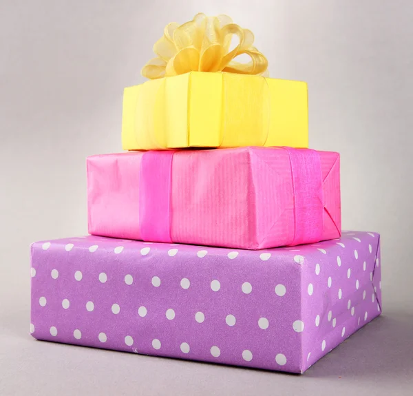 Bright gifts with bows on grey background — Stock Photo, Image