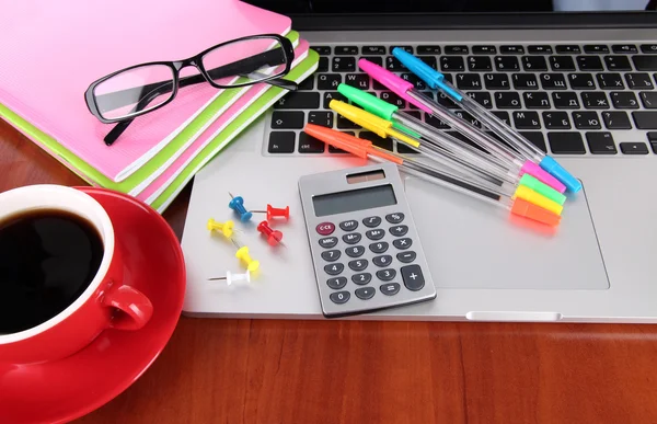 Laptop mit Schreibwaren und Tasse Kaffee auf dem Tisch — Stockfoto