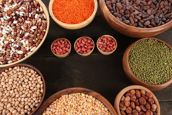 Různé druhy fazolí v miskách na tabulka detail — Stock fotografie