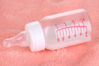 pembe havlu zemin üzerine süt şişesi