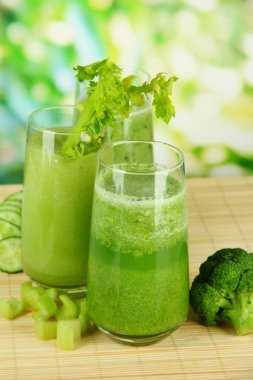 Bambu mat yeşil zemin üzerine yeşil sebze suyu bir bardak