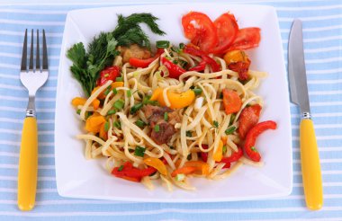 peçete üzerinde beyaz izole bir tabakta sebze erişte