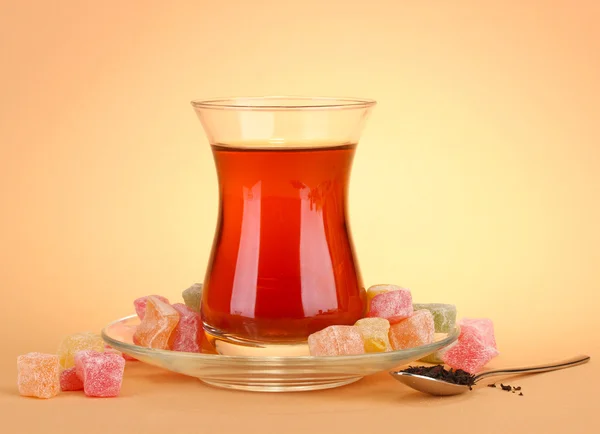 Стакан турецкого чая и рахат Очарование, на бежевом фоне — стоковое фото
