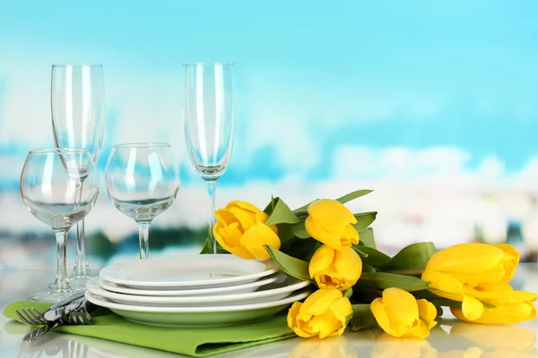 Yellow tulips and utensils for serving on blue natural background background — Stock Photo, Image