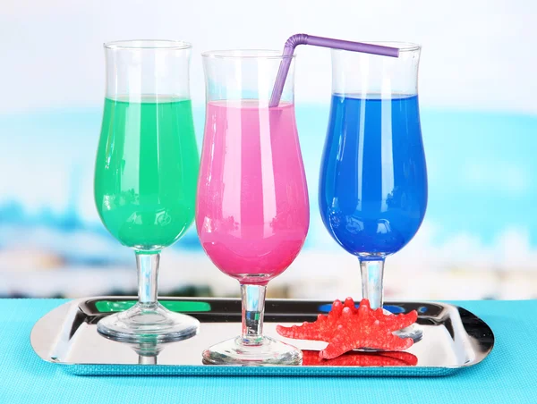 Brýle koktejlů na stole poblíž bazén — Stock fotografie