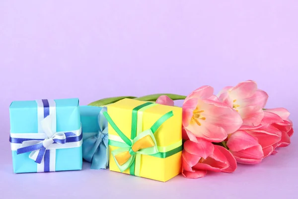 Tulipas cor-de-rosa e caixas de presente, em fundo de cor — Fotografia de Stock