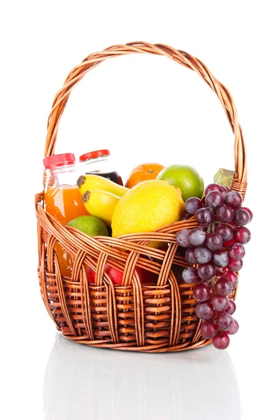 Frutos diferentes em cesta de vime com suco isolado em branco — Fotografia de Stock