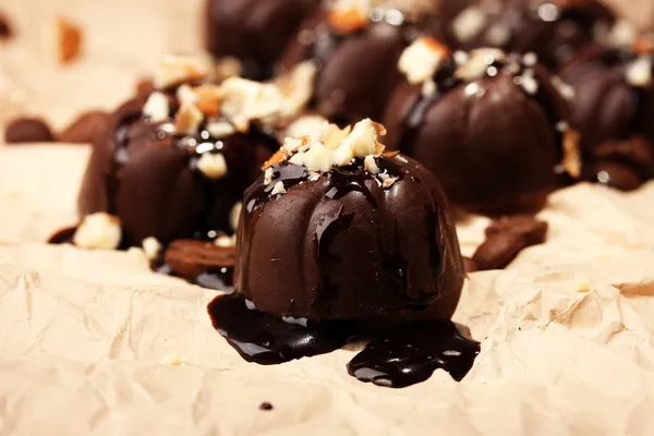 Caramelle al cioccolato e chicchi di caffè, su sfondo di carta beige — Foto Stock