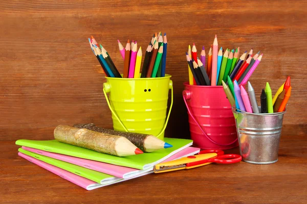 Buntstifte mit Schulmaterial auf Holzgrund — Stockfoto