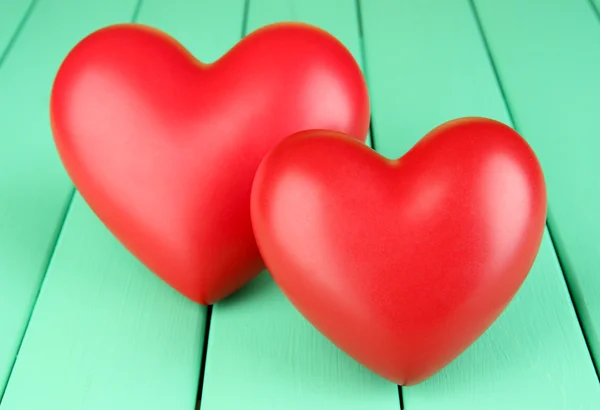 Dekorativní červené srdce na barevné dřevěné pozadí — Stock fotografie