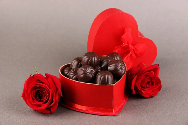 Chocolade snoepjes in de doos van de gift, op grijze achtergrond — Stockfoto