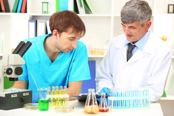 Médico y ensayador durante la investigación sobre el fondo de la habitación — Foto de Stock