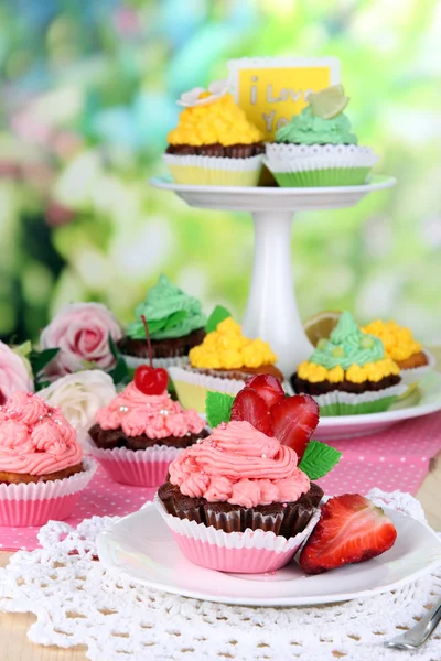 Hermosos cupcakes en mesa de comedor sobre fondo natural — Foto de Stock