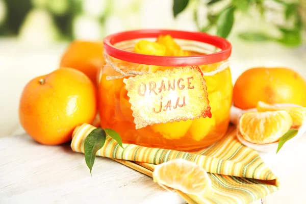 Sinaasappeljam met schil en mandarijnen, op witte houten tafel — Stockfoto