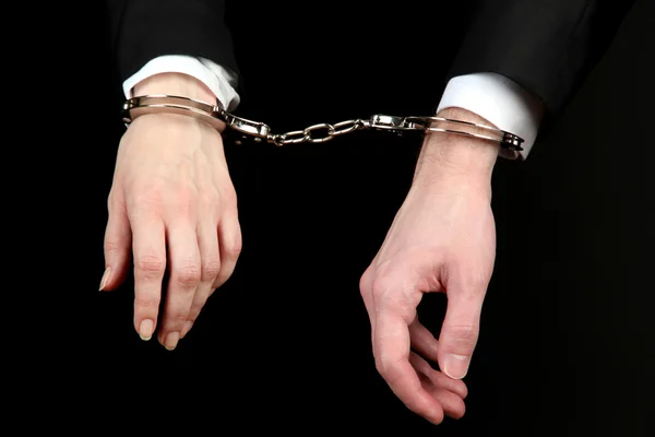 Man and woman hands and breaking handcuffs isolated on black background — Stock Photo, Image