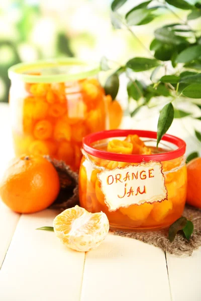 Oranžový jam s kůrou a mandarinky, na bílý dřevěný stůl — Stock fotografie