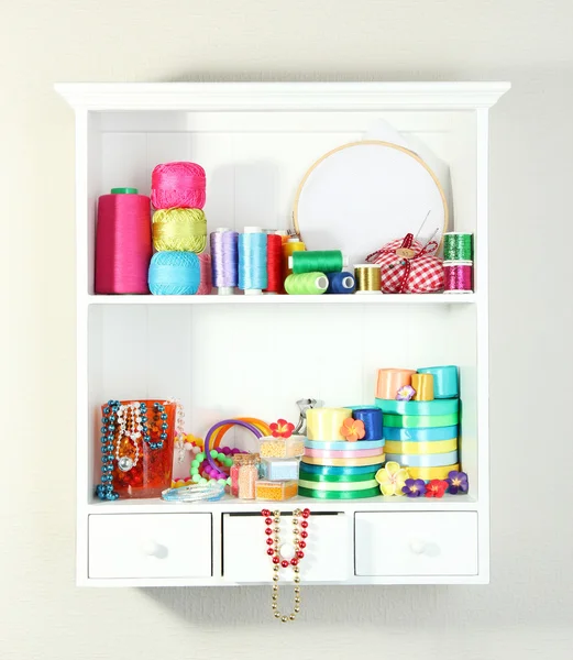 Beautiful white shelves with thread and material for handicrafts — Stock Photo, Image