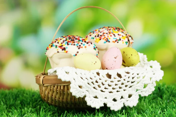 Torta di Pasqua con uova in cesto di vimini sull'erba — Foto Stock