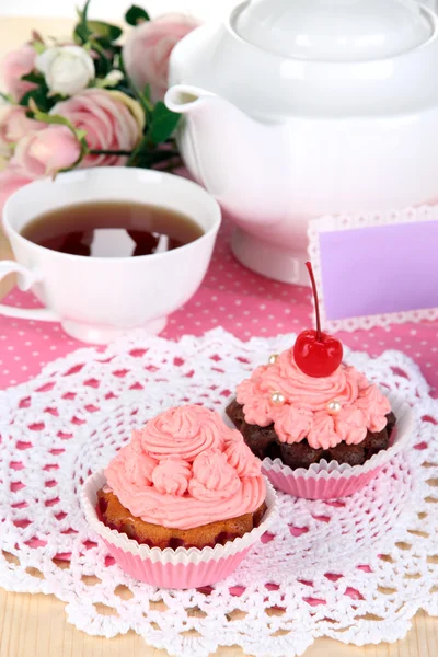 Beautiful strawberry cupcakes and flavored tea on dining table close-up — Stock Photo, Image