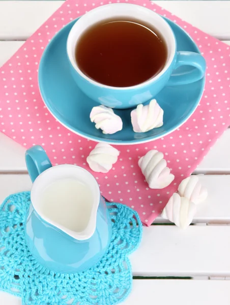 Beautiful composition with cup of tea and marshmallow on wooden picnic table close-up — Stock Photo, Image