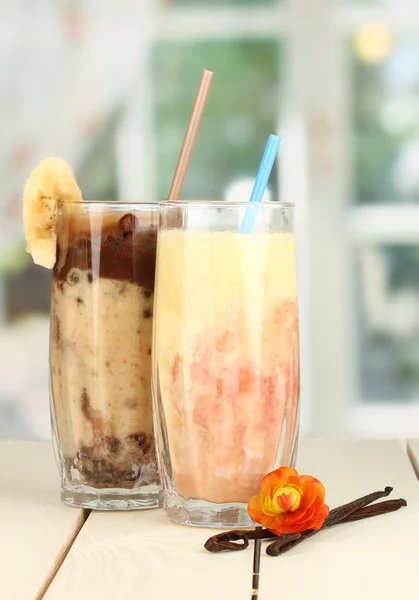 Deliciosos smoothies de frutas na mesa de madeira no fundo da janela — Fotografia de Stock