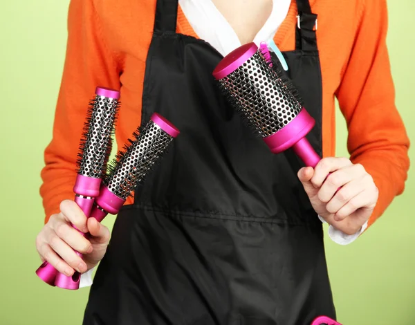 Peluquería en uniforme con herramientas de trabajo, sobre fondo de color — Foto de Stock