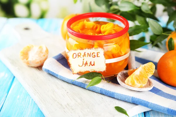 Mermelada de naranja con ralladura y mandarinas, sobre mesa de madera azul — Foto de Stock